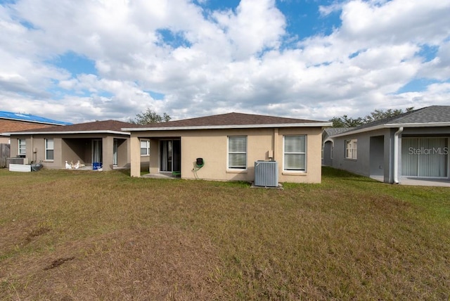 back of property with a yard and central AC unit