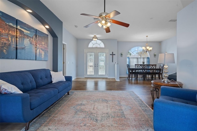 living room with french doors, ceiling fan with notable chandelier, and dark hardwood / wood-style flooring