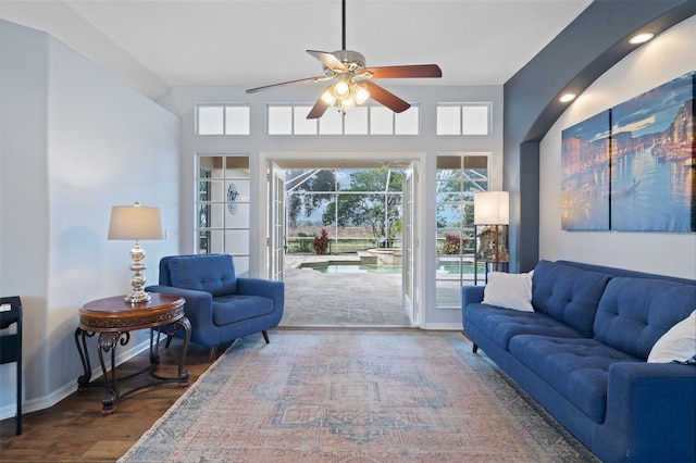 living room with ceiling fan and dark wood-type flooring