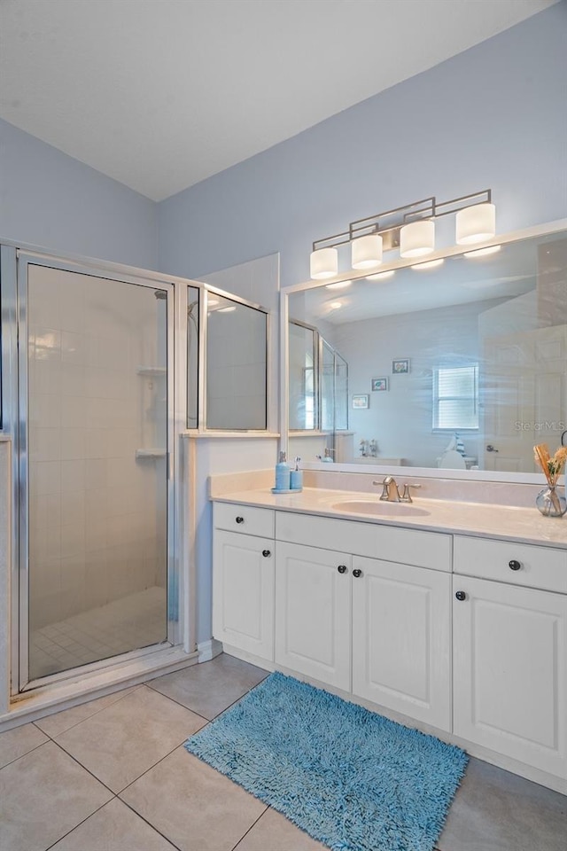 bathroom with tile patterned floors, vanity, and a shower with shower door