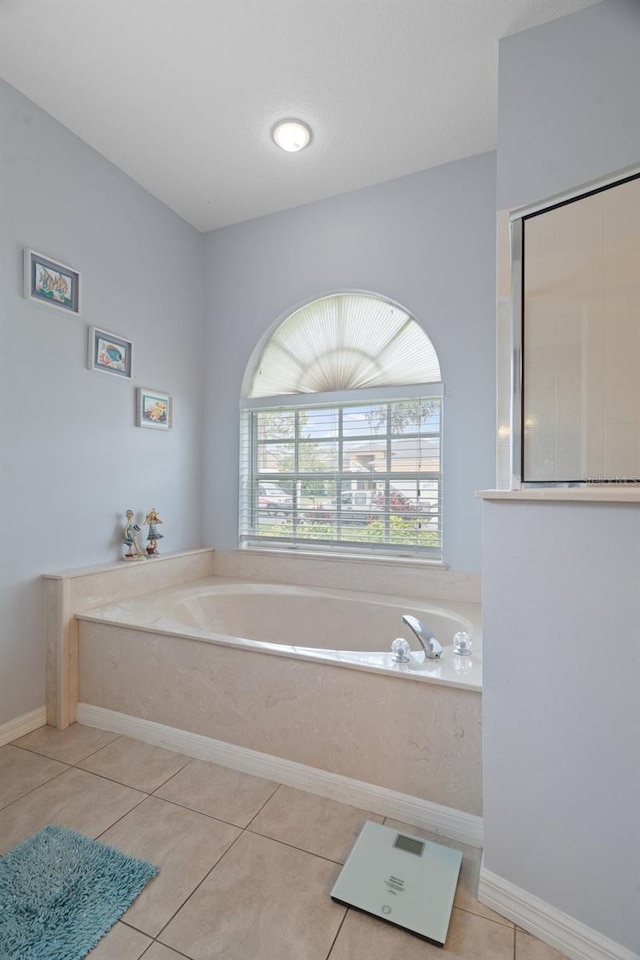 bathroom featuring tile patterned floors and a tub to relax in