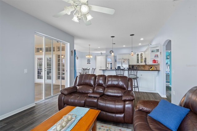 living room featuring ceiling fan and dark hardwood / wood-style floors