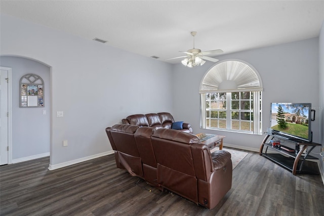 living room with ceiling fan and dark wood-type flooring