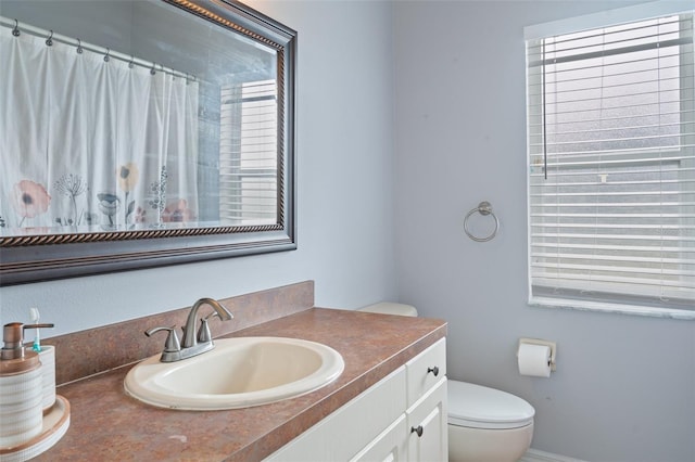 bathroom with vanity, toilet, and walk in shower