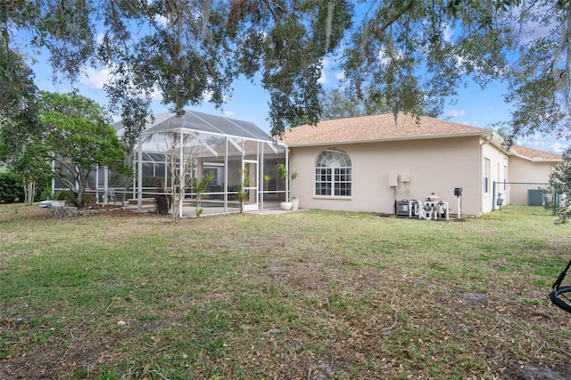 back of property featuring central AC, a lanai, and a lawn