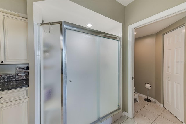 bathroom featuring a shower with door and tile patterned flooring