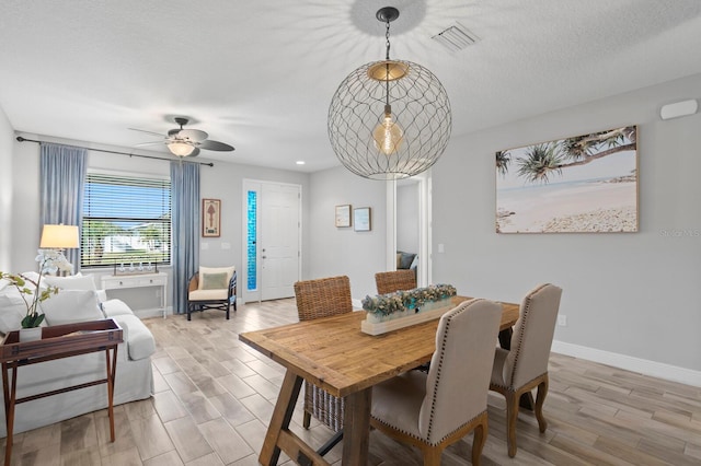 dining room featuring ceiling fan, light hardwood / wood-style flooring, and a textured ceiling