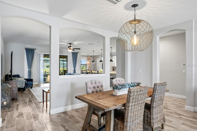 dining room featuring ceiling fan, a textured ceiling, and light wood-type flooring