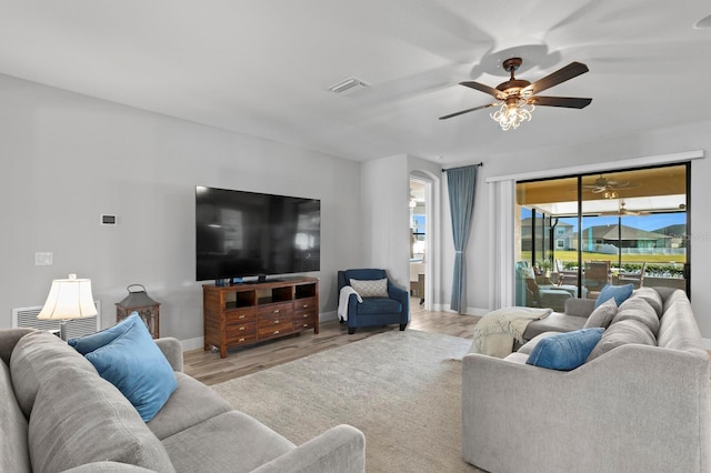 living room featuring ceiling fan and light hardwood / wood-style flooring