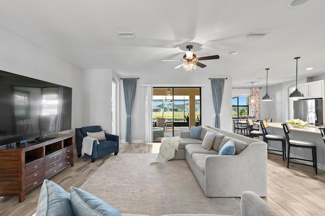 living room featuring ceiling fan and light hardwood / wood-style floors