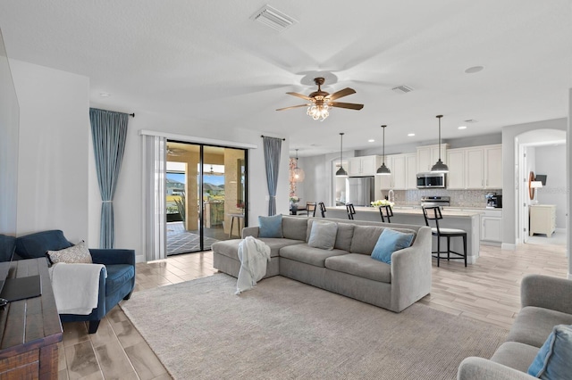 living room with light hardwood / wood-style floors and ceiling fan