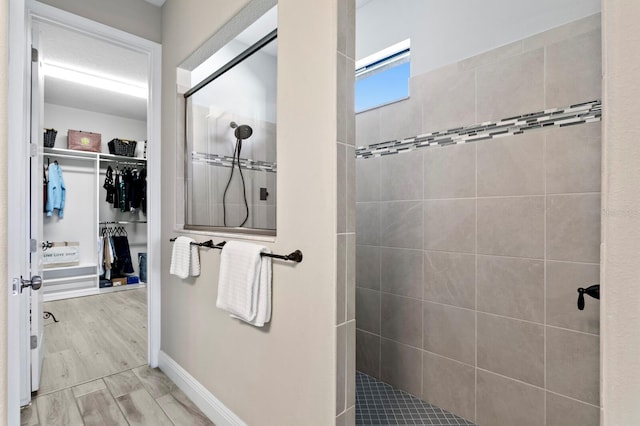 bathroom with hardwood / wood-style flooring and a tile shower