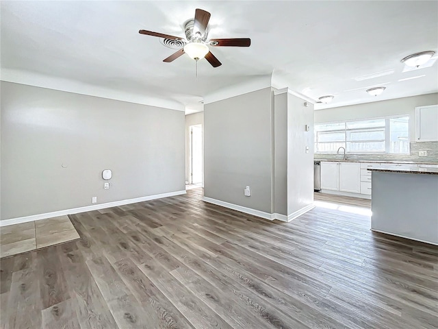 unfurnished living room with hardwood / wood-style floors, ceiling fan, and sink