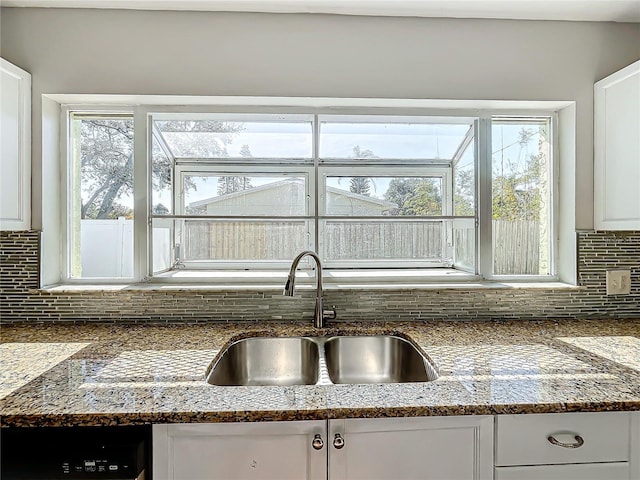 kitchen with tasteful backsplash, sink, white cabinets, and plenty of natural light