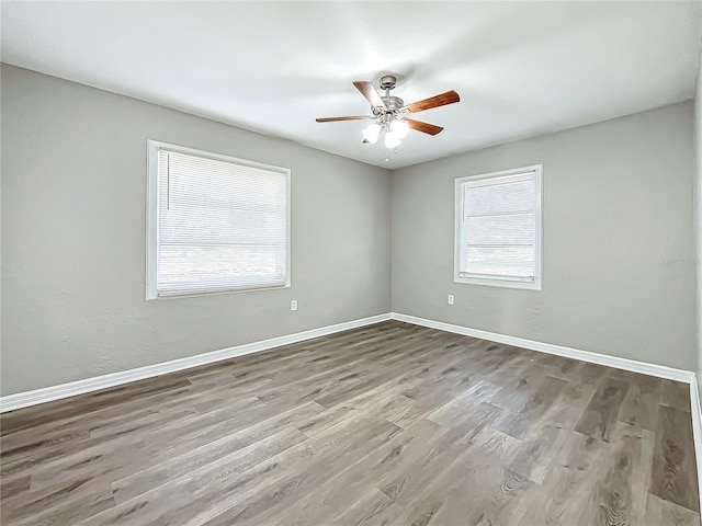 empty room with light wood-type flooring, ceiling fan, and a healthy amount of sunlight