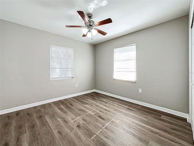 unfurnished room with ceiling fan and dark wood-type flooring