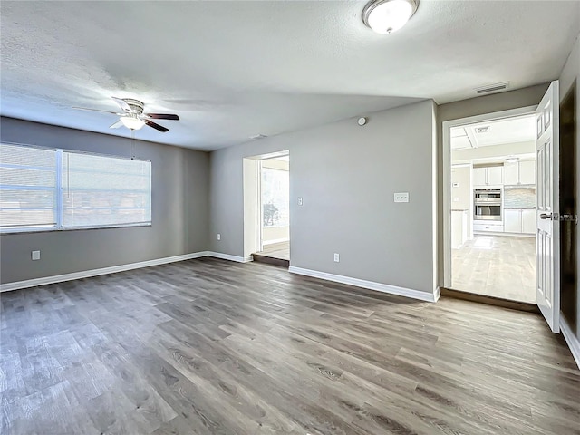 empty room with ceiling fan and wood-type flooring