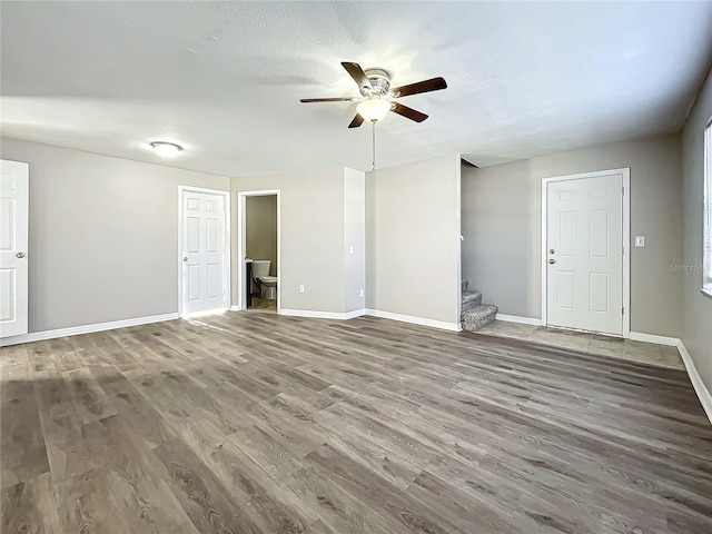 unfurnished living room with hardwood / wood-style floors, ceiling fan, and a textured ceiling