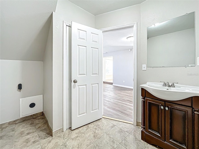 bathroom with vanity and lofted ceiling