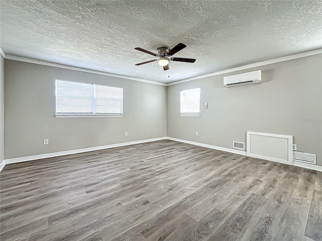 unfurnished room featuring a wall mounted air conditioner, crown molding, and hardwood / wood-style floors