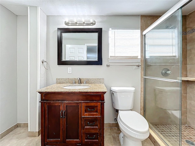 bathroom with tile patterned flooring, vanity, toilet, and walk in shower