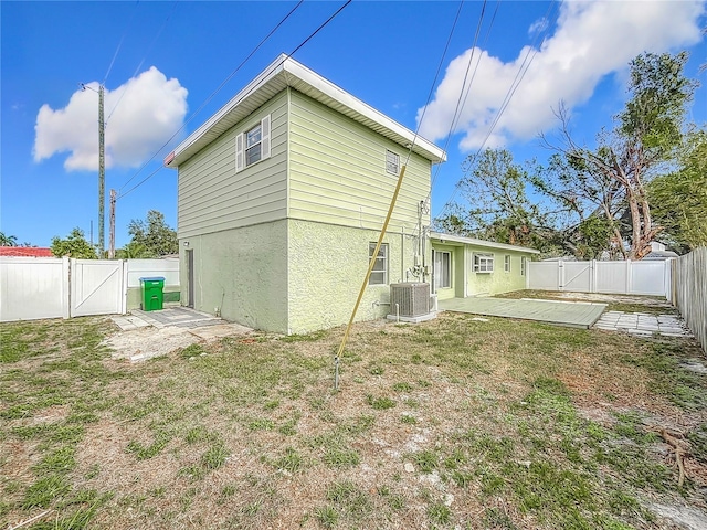 rear view of house with a yard and cooling unit