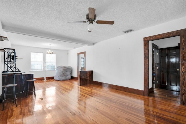 living room with a textured ceiling, ceiling fan with notable chandelier, and hardwood / wood-style flooring