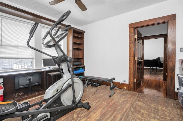 exercise room featuring a textured ceiling, dark hardwood / wood-style flooring, and ceiling fan