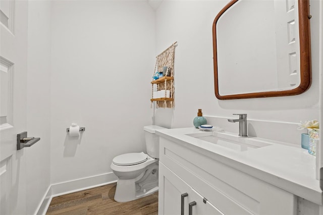 bathroom featuring toilet, vanity, and hardwood / wood-style floors