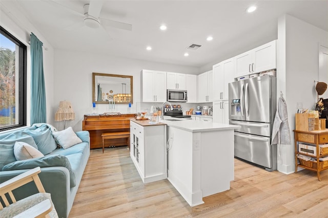 kitchen featuring white cabinets, light wood-type flooring, ceiling fan, and appliances with stainless steel finishes