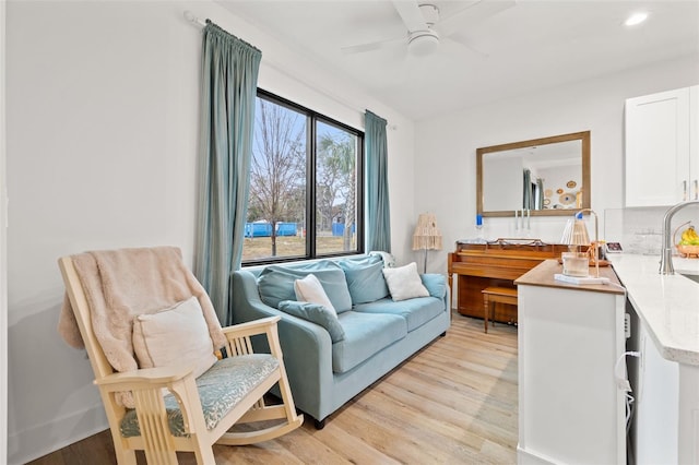 living room featuring ceiling fan and light wood-type flooring