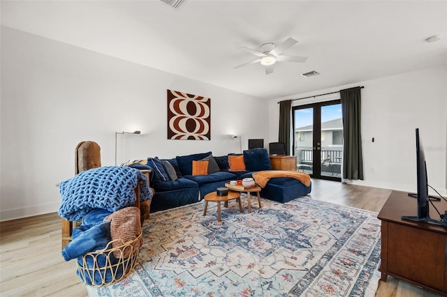 living room featuring french doors, light wood-type flooring, and ceiling fan