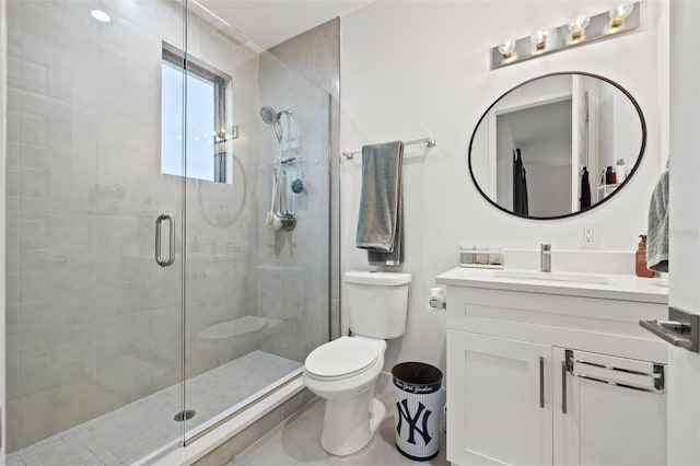 bathroom with toilet, a shower with door, and vanity