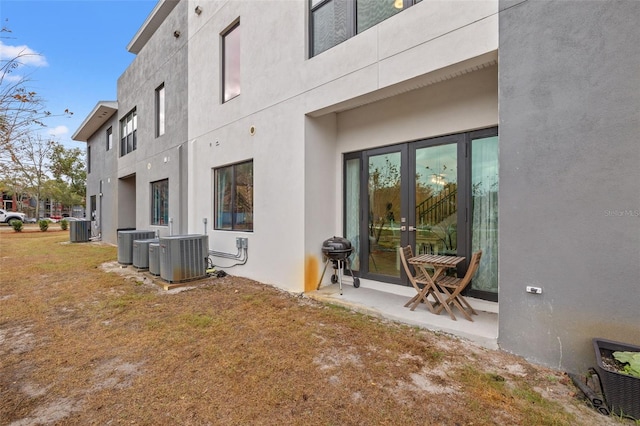 back of house with a lawn and central AC unit