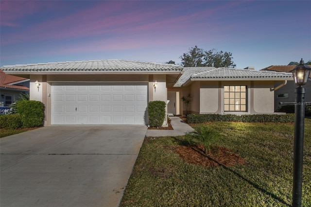 view of front of house with a garage and a yard