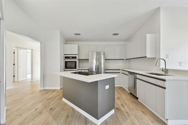 kitchen featuring light hardwood / wood-style floors, stainless steel appliances, a center island, and sink