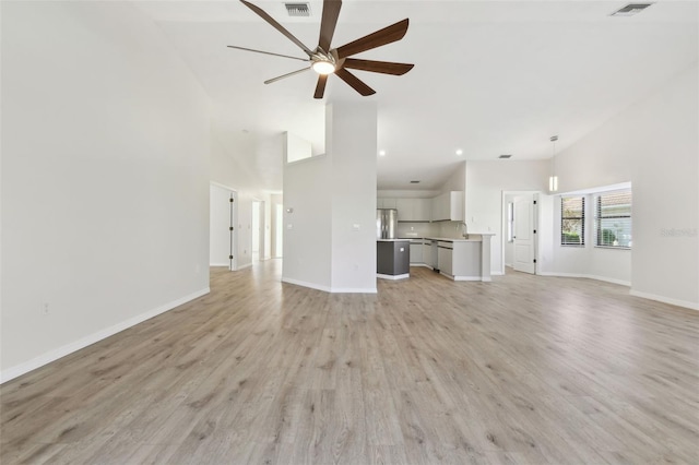 unfurnished living room with high vaulted ceiling, light wood-type flooring, and ceiling fan