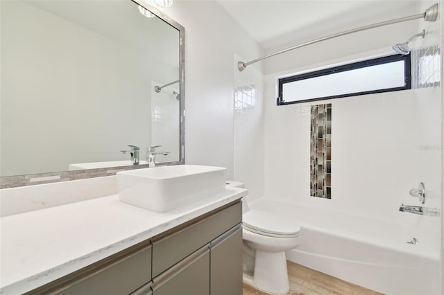 full bathroom with vanity, hardwood / wood-style floors, tiled shower / bath, and toilet