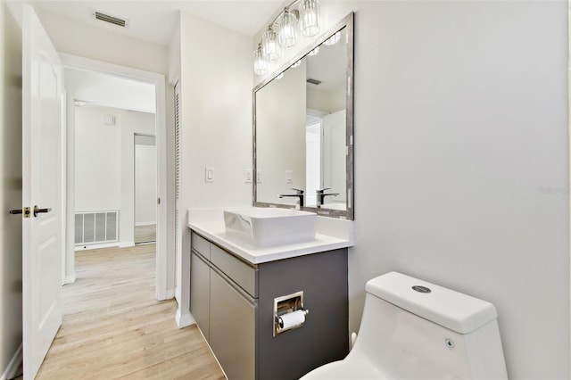 bathroom featuring vanity, hardwood / wood-style flooring, and toilet