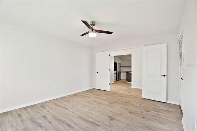 unfurnished bedroom with light hardwood / wood-style flooring, stainless steel fridge, a closet, and ceiling fan