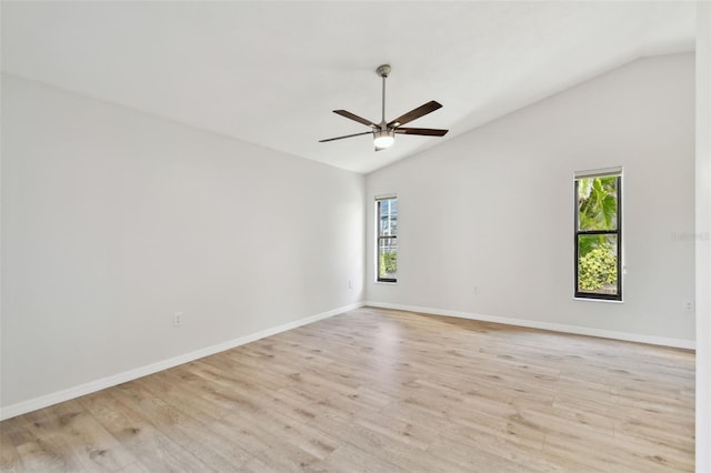 empty room featuring ceiling fan, lofted ceiling, light hardwood / wood-style floors, and plenty of natural light