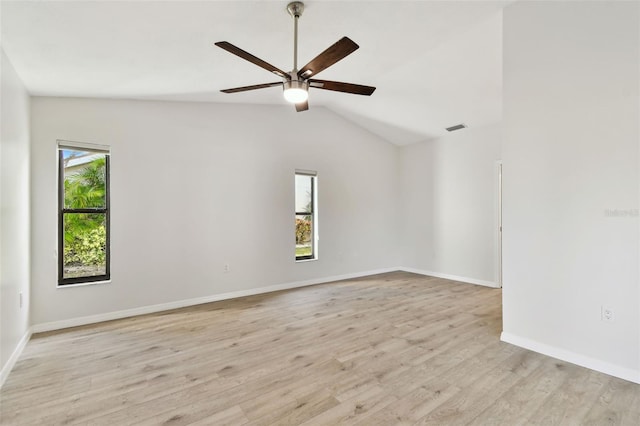 empty room featuring lofted ceiling, ceiling fan, a healthy amount of sunlight, and light wood-type flooring