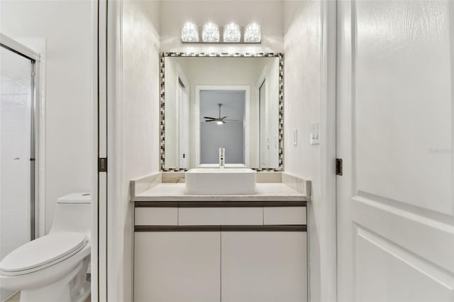 bathroom featuring walk in shower, ceiling fan, vanity, and toilet