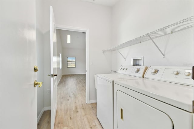 laundry room with light hardwood / wood-style floors and independent washer and dryer