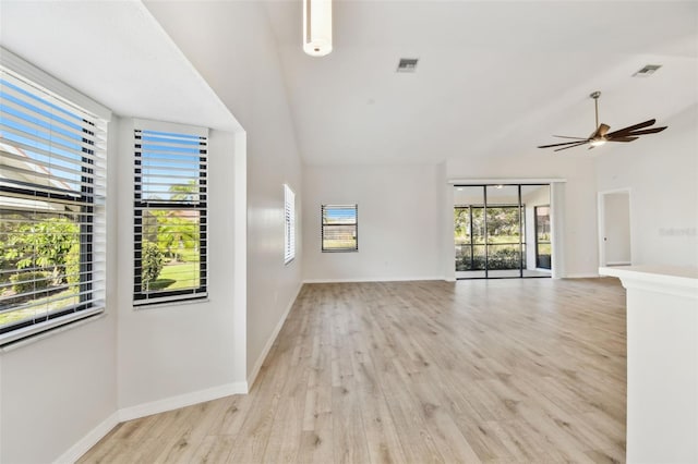 unfurnished living room with ceiling fan, a healthy amount of sunlight, vaulted ceiling, and light hardwood / wood-style flooring