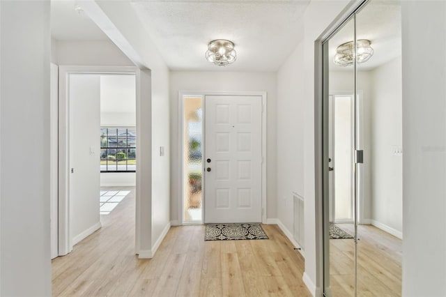 entrance foyer with light hardwood / wood-style flooring and a textured ceiling