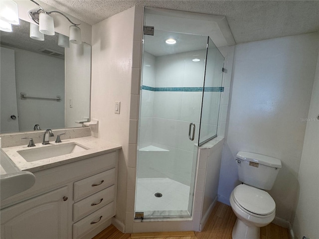 bathroom with walk in shower, toilet, a textured ceiling, vanity, and hardwood / wood-style floors