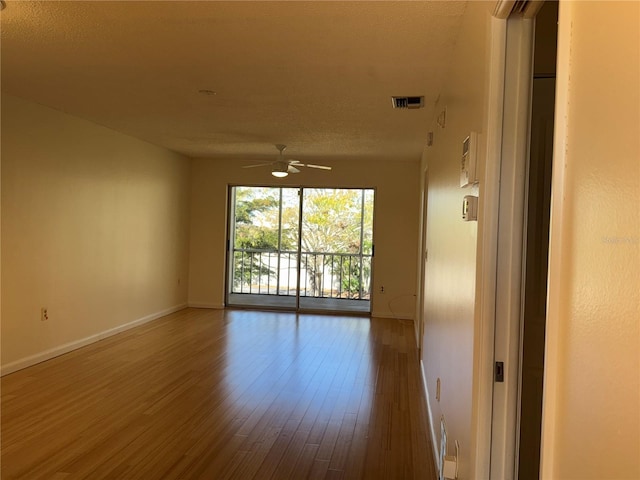 unfurnished room with hardwood / wood-style floors, a textured ceiling, and ceiling fan