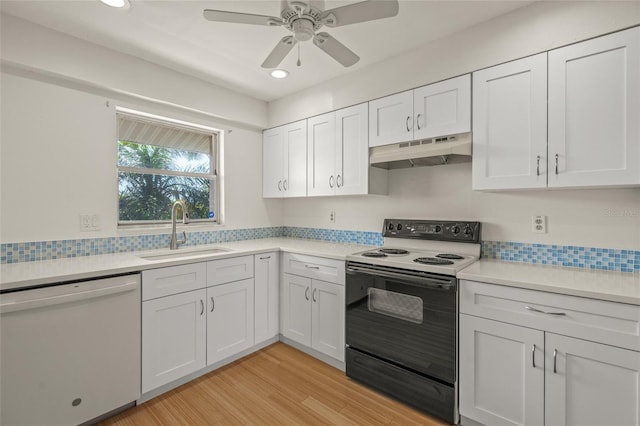 kitchen featuring black / electric stove, white dishwasher, sink, and white cabinets