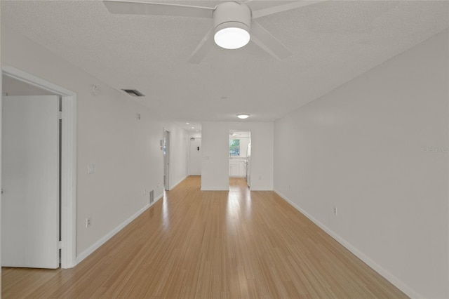 spare room featuring ceiling fan, light hardwood / wood-style flooring, and a textured ceiling